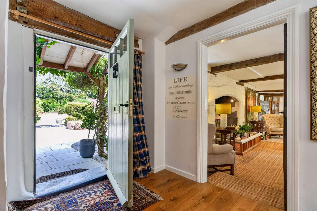 The entrance hall at Priors Court, Aylton, with the front door open onto the garden