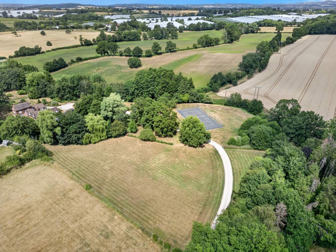 Aerial view of Priors Court, Aylton, showing the private lake, hard tennis court and driveway within the grounds