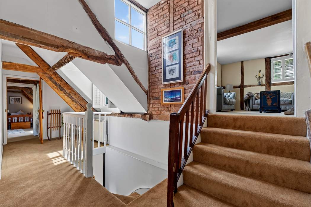 The first-floor landing at Priors Court, Aylton, with exposed brickwork and roof timbers