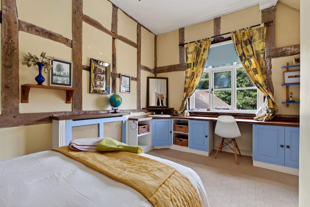A further first-floor bedroom at Priors Court, Aylton, with fitted furniture and a study corner