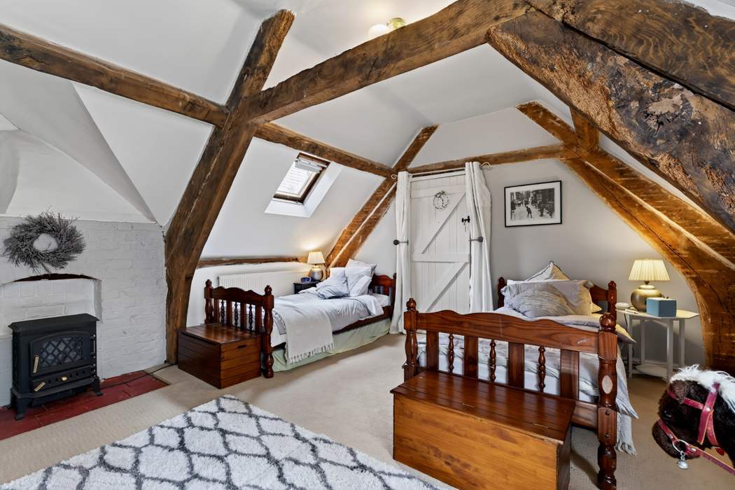 A twin bedroom at Priors Court, Aylton, with a wood-burning stove