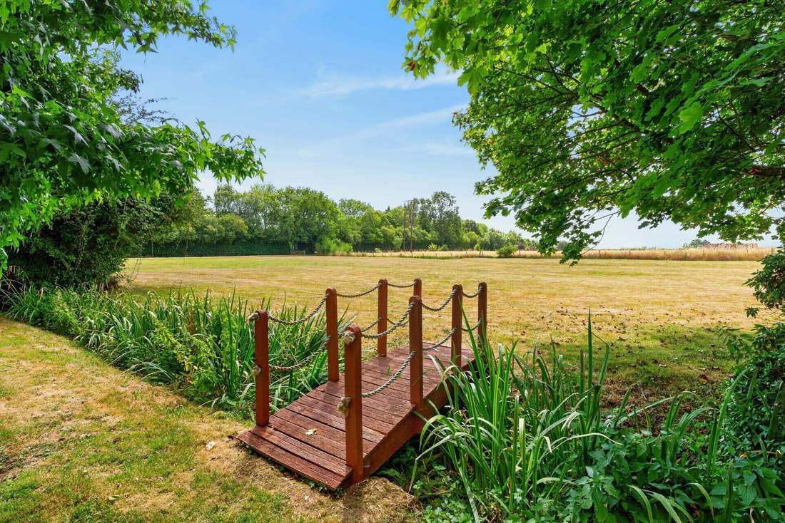 A footbridge over the grounds at Priors Court, Aylton, leading toward the adjoining field